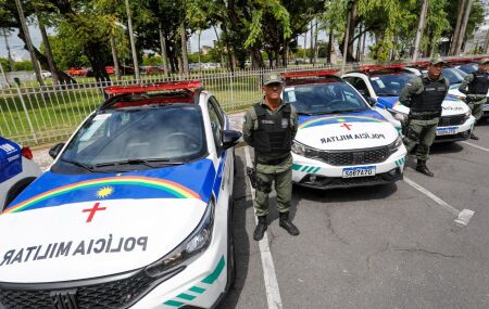 Agente da PMPE ao lado de viaturas.