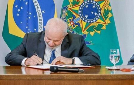 Lula assinando documento.