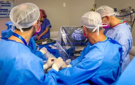 M&eacute;dicos realizando cirurgia em beb&ecirc; no &uacute;tero. 