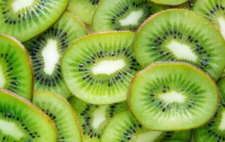 Kiwi cortado ao meio revela a polpa verde e as pequenas sementes caracter&iacute;sticas da fruta.