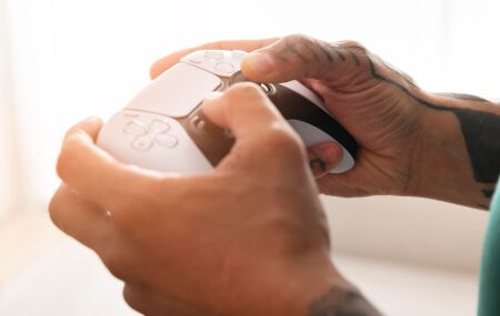 Pessoa joga usando o controle do PS5 em um momento de lazer.