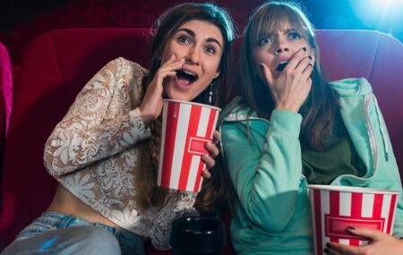 Duas pessoas assistem a um filme em uma sess&atilde;o do cinema, aproveitando a experi&ecirc;ncia da telona.