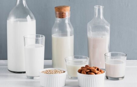 Diversos tipos de leite na mesa, mostrando varia&ccedil;&otilde;es de cor e textura.