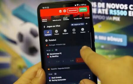 Pessoa mexendo em aplicativo de apostas no celular.