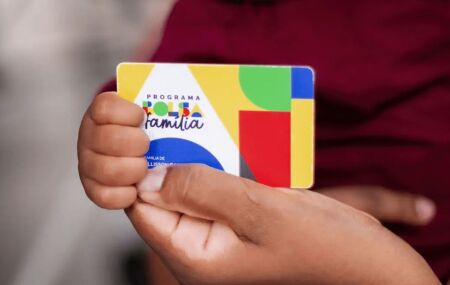 Pessoa segurando cart&atilde;o do Bolsa Fam&iacute;lia.