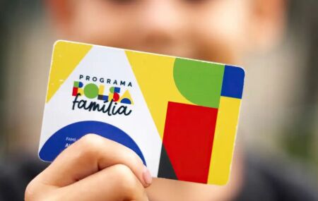 Crian&ccedil;a segurando cart&atilde;o do Bolsa Fam&iacute;lia.