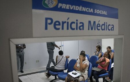 Fila do INSS com pessoas esperando per&iacute;cia m&eacute;dica.