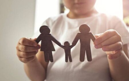 Crian&ccedil;a com bonecos representando pai e m&atilde;e.