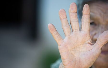 Pessoa idosa estendendo a m&atilde;o.
