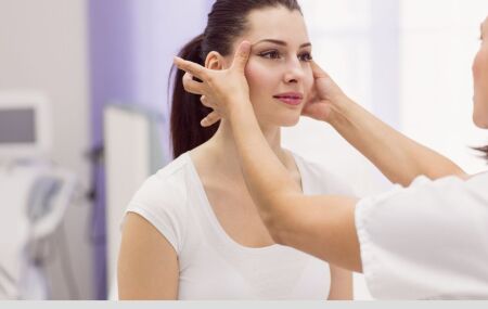 Profissional avalia paciente antes de procedimento facial, destacando a import&acirc;ncia de cuidados e seguran&ccedil;a.