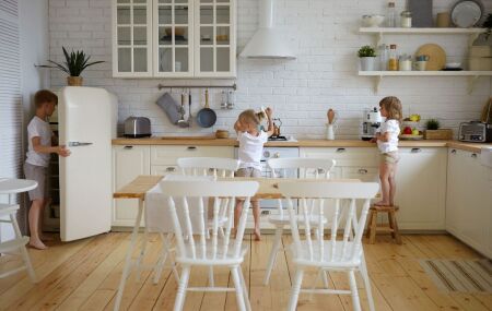 Cozinha com arm&aacute;rios em tom creme e bancada de madeira, ilustrando a nova paleta crom&aacute;tica apontada para 2026.