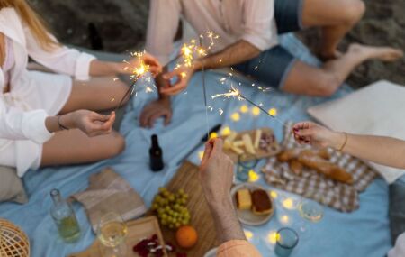 Pessoas celebrando a virada de ano com simpatias tradicionais, entre uvas, roupas brancas, em busca de boas energias.