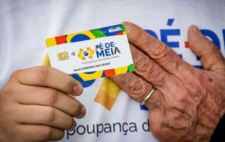 M&atilde;o do presidente Lula e pessoa segurando cart&atilde;o do P&eacute;-de-Meia.