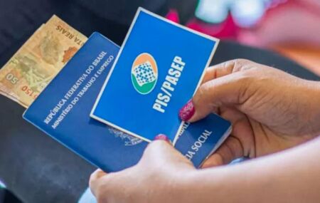 Mulher com cart&atilde;o do PIS/Pasep e dinheiro do benef&iacute;cio.