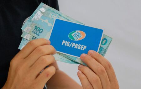 Pessoa com cart&atilde;o do PIS/Pasep e dinheiro do abono.
