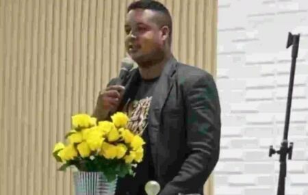 Pastor aparece em foto posada diante de fundo amarelo. 