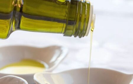 Garrafa com azeite de oliva sendo derramado.