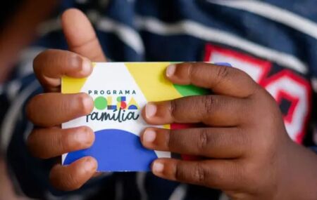 Crian&ccedil;a segurando cart&atilde;o de benefici&aacute;rio do Bolsa Fam&iacute;lia.