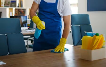 Homem limpando uma mesa de uma casa.
