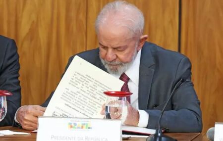 Lula assinando. 