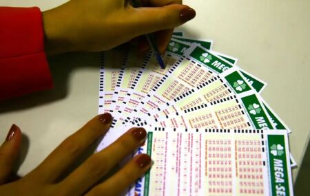 Mulher marcando cartelas da Mega-Sena.