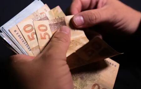 Pessoa contanto notas de dinheiro.