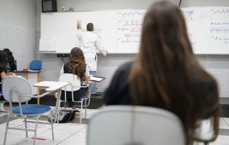 Professor em sala de universidade dando aula.