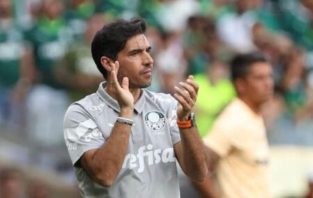 T&eacute;cnico do Palmeiras aplaude &agrave; beira do campo durante partida, uniforme cinza de comiss&atilde;o t&eacute;cnica e torcida ao fundo