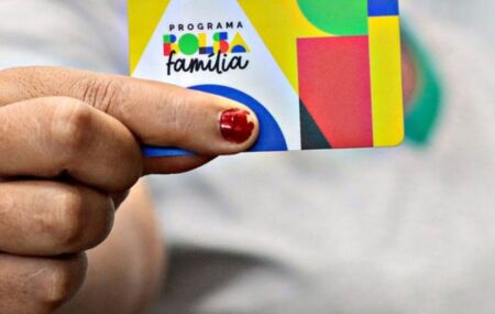 Mulher segurando cart&atilde;o do Bolsa Fam&iacute;lia.