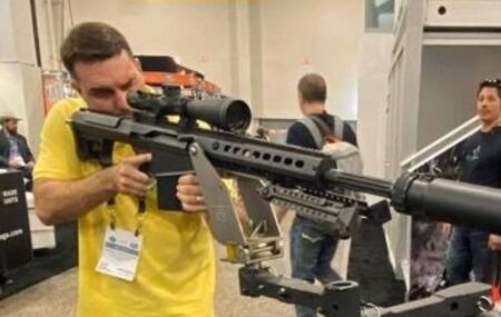 Fl&aacute;vio Bolsonaro segurando arma.