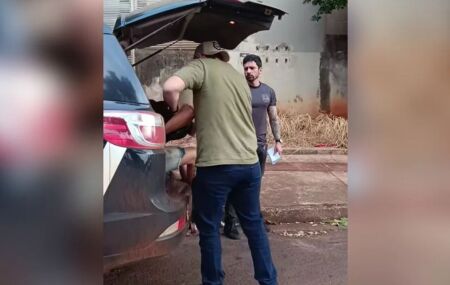 Momento em que suspeitos s&atilde;o colocados na viatura.