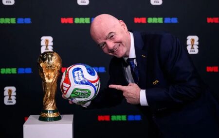 Presidente da FIFA com a bola e a ta&ccedil;a da Copa do Mundo de 2026 