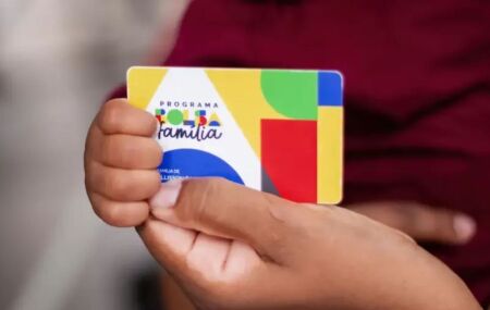 Pessoa segurando cart&atilde;o do Bolsa Fam&iacute;lia.