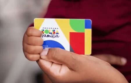 Pessoa segurando cart&atilde;o do Bolsa Fam&iacute;lia.