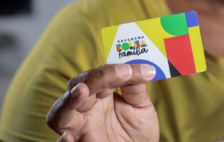Homem segurando cart&atilde;o do Bolsa Fam&iacute;lia.