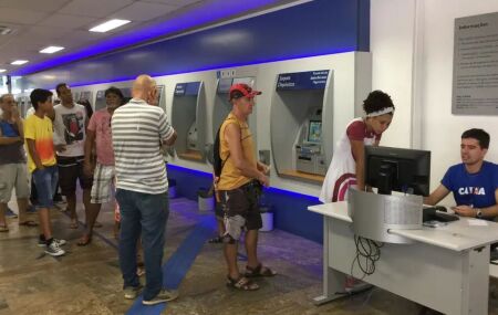 Pessoas em ag&ecirc;ncia banc&aacute;ria.