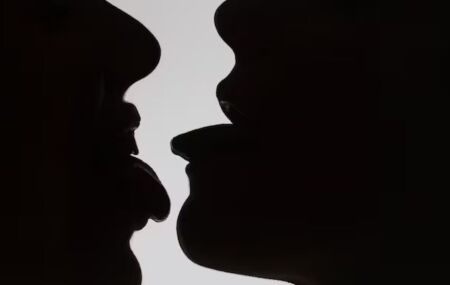 Silhuetas de pessoas se beijando.