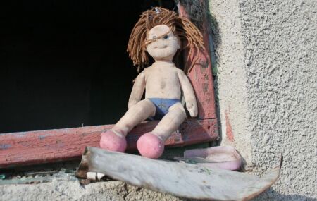 Boneca de menina em janela.