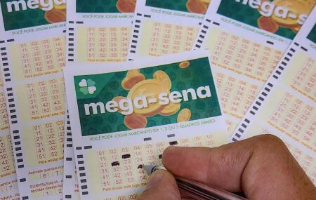 Pessoa marcando cartelas da Mega-Sena.