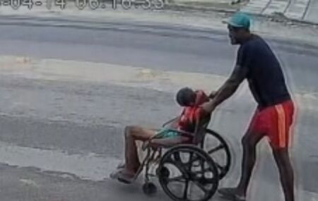 Filho empurrando pai morto na cadeira de rodas. 