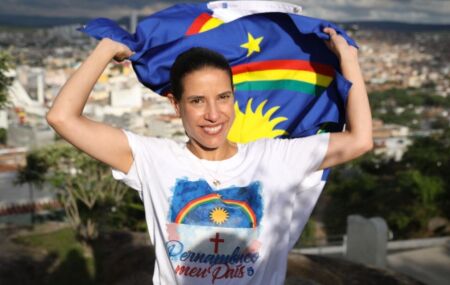 Raquel Lyra segurando a bandeira de Pernambuco.