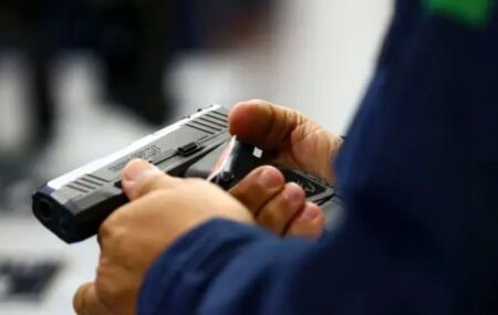 Homem segurando arma.