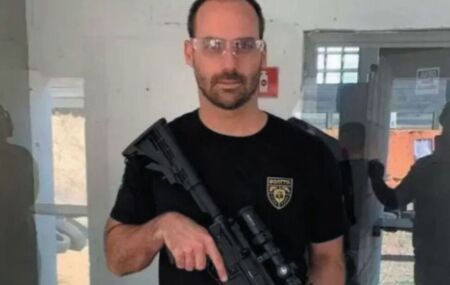 Eduardo Bolsonaro segurando arma.