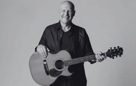 Brian Doerksen em retrato promocional segurando um viol&atilde;o. 
