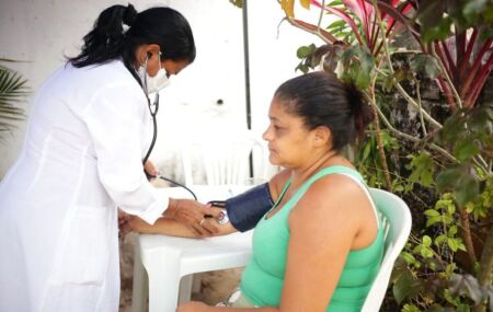 Paciente sendo examinada por uma profissional da sa&uacute;de que atende a iniciativa disponibilizada no munic&iacute;pio.