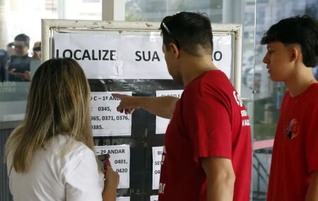 Eleitores consultando se&ccedil;&atilde;o de vota&ccedil;&atilde;o.