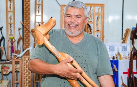 O artista Marcos de Sert&acirc;nia exibe uma de suas esculturas em madeira.