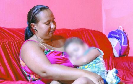 M&atilde;e segura crian&ccedil;a no colo em caso relacionado &agrave; troca de beb&ecirc;s.