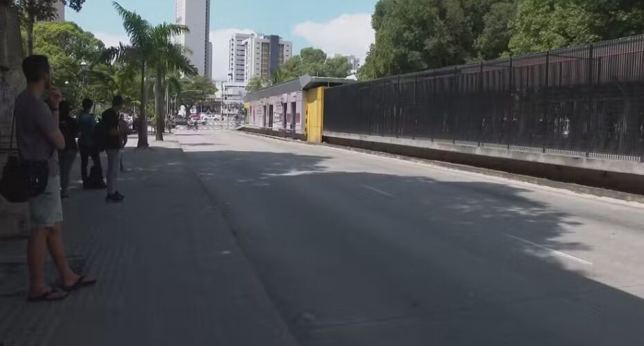 Passageiros no Recife esperando ônibus em parada.