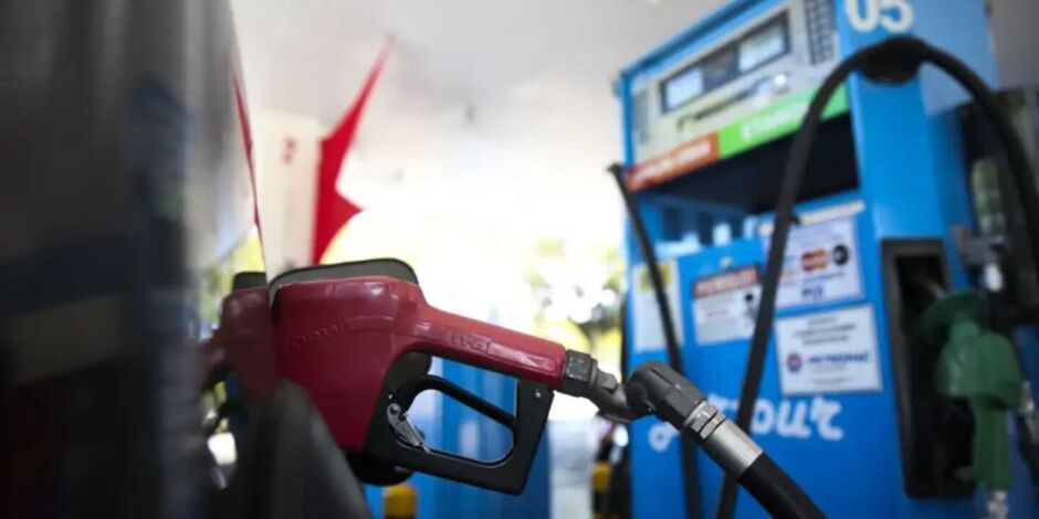 Bomba abastecendo carro em posto de combust&iacute;vel.